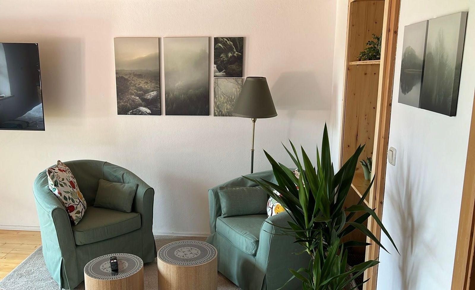 Gemütliche Sitzecke der Ferienwohnung Bergblick mit grünen Sesseln und Stehleuchte